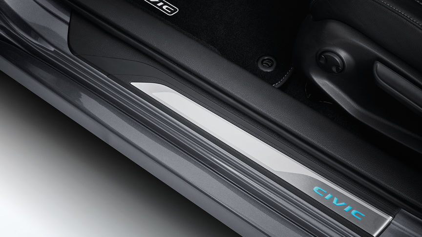 Plan rapproché des garnitures de seuil de porte illuminées de la Honda Civic 4 portes.