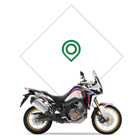 Badge ail&eacute; Honda, sur r&eacute;servoir de moto rouge.