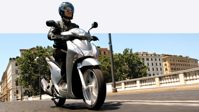 Vue de trois quarts du SH125i. En ville.