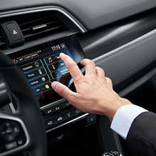 Homme appuyant sur le système Honda Connect dans la console