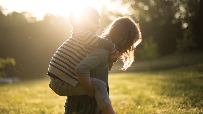 Une jeune fille portant son petite frère