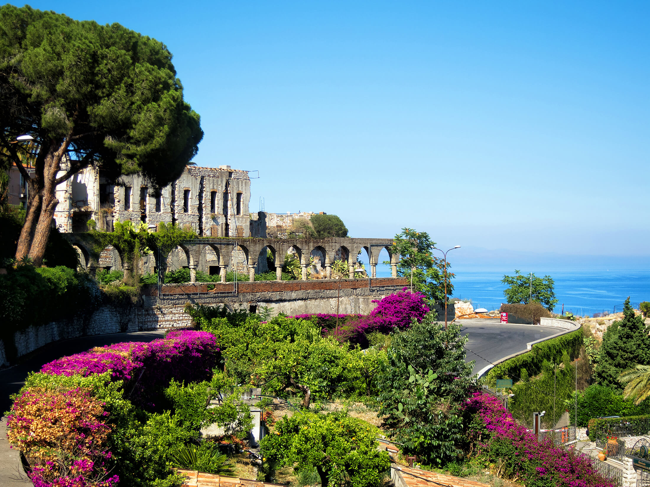 Un jardin aux mille couleurs à proximité d’un vieux bâtiment en Sicile, Italie