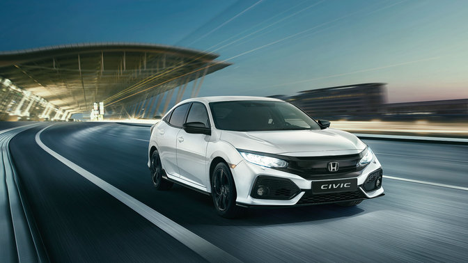 Vue de trois quarts avant de la Honda Civic Black Edition, roulant dans un paysage urbain.