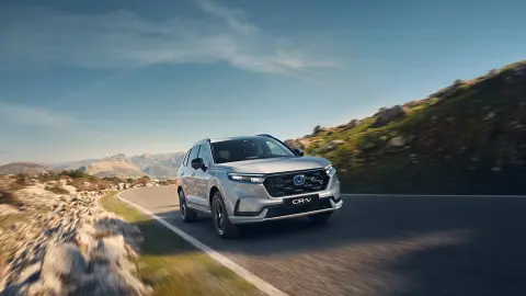 Vue de face du SUV CR-V hybride circulant en montagne.