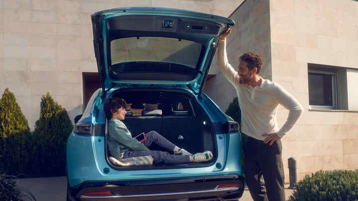 Père parlant à un enfant assis dans le coffre du Honda e:Ny1.