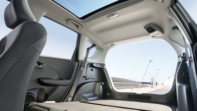 Vue de trois quarts avant de la Honda Jazz sur une route de montagne expos&eacute;e au vent.