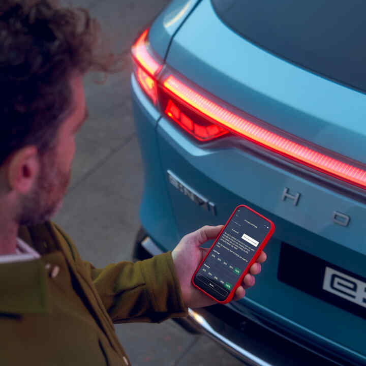 Gros plan de l'application My Honda+ sur l'écran du téléphone d'une personne se trouvant à l'extérieur d'un véhicule