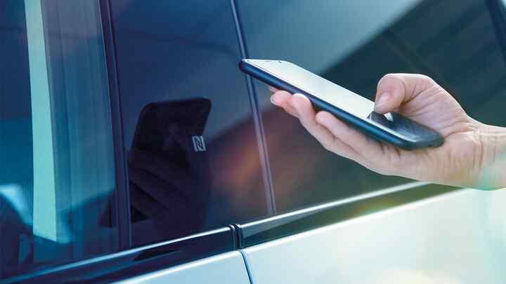 Gros plan de l'application My Honda+ sur l'écran du téléphone d'une personne se trouvant à l'extérieur d'un véhicule