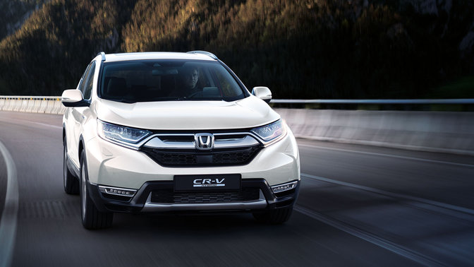 Vue de trois quarts avant du Honda CR-V, roulant dans un environnement montagneux.