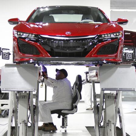 Vue avant de la NSX avec un technicien Honda en cours d'intervention.