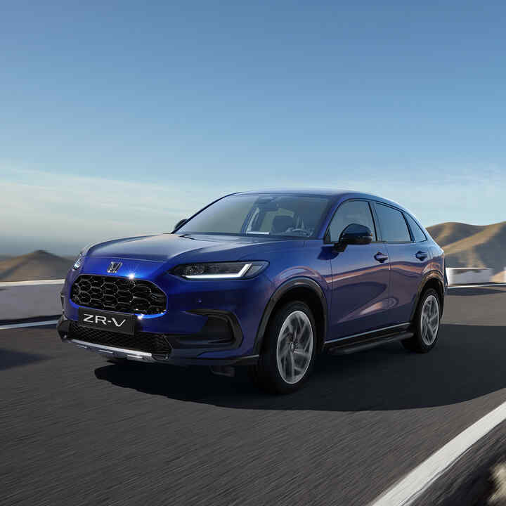 Vue de trois quarts avant du Honda ZR-V avec pack Robust en zone montagneuse.