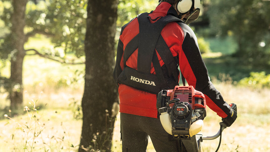 Débroussailleuse à dos en cours d'utilisation en forêt.