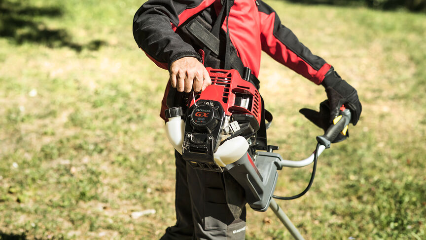 Débroussailleuse à dos en cours d'utilisation en forêt.