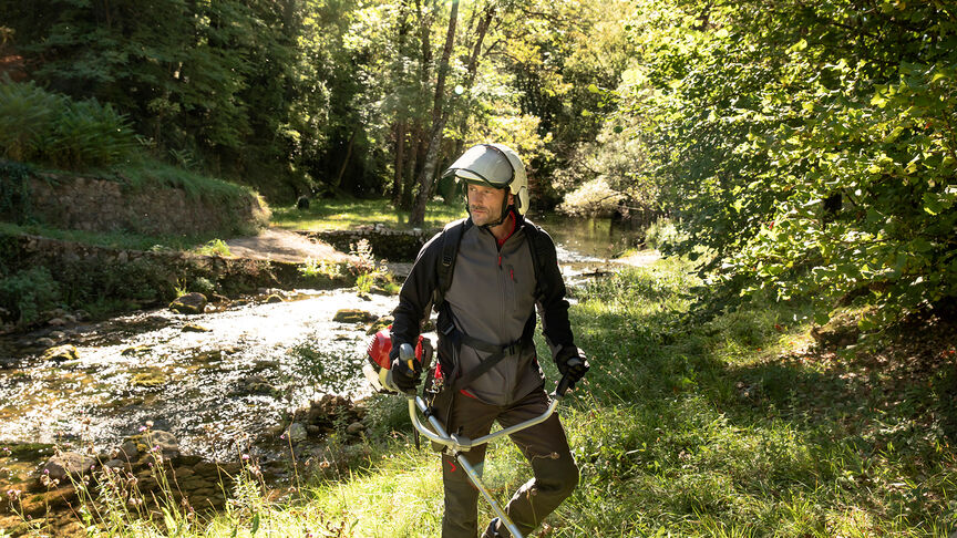 Débroussailleuse à dos en cours d'utilisation en forêt.