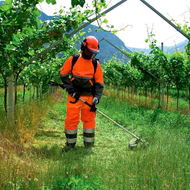 Débroussailleuse à dos Honda en cours d'utilisation dans un champ.