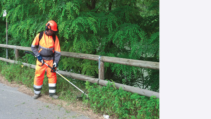 Débroussailleuse à dos Honda, utilisée par un démonstrateur, sur un terrain vert.