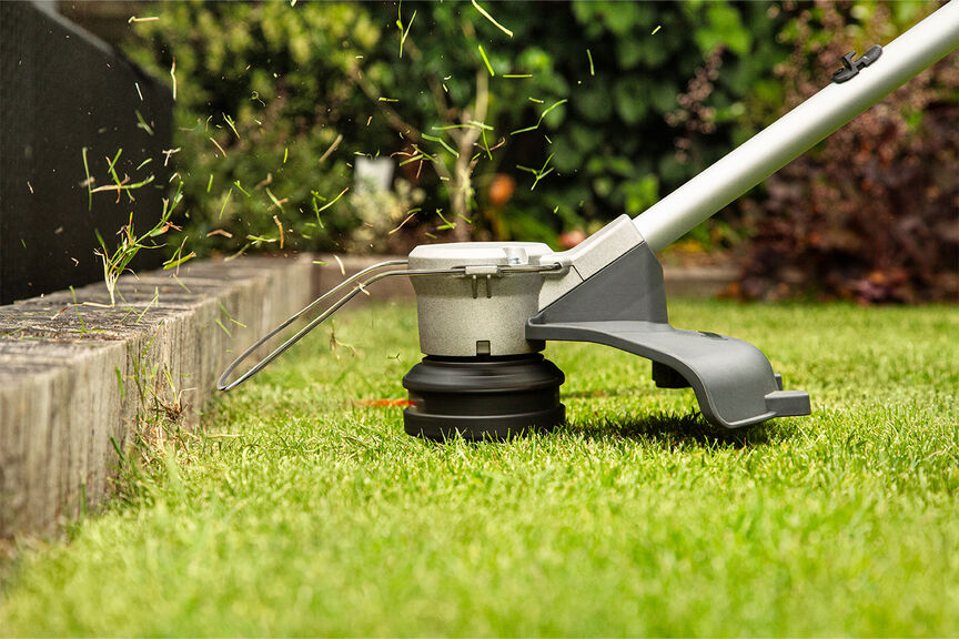 Coupe-bordure sans fil faisant la preuve d'une ligne de coupe de haute qualité sur la pelouse.