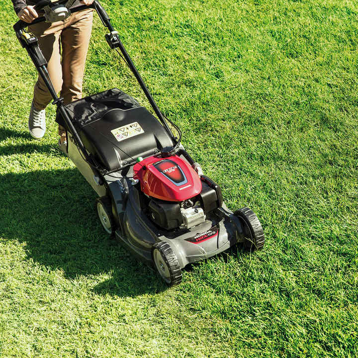 Tondeuse à gazon Honda HRX de trois-quarts face dans un jardin.