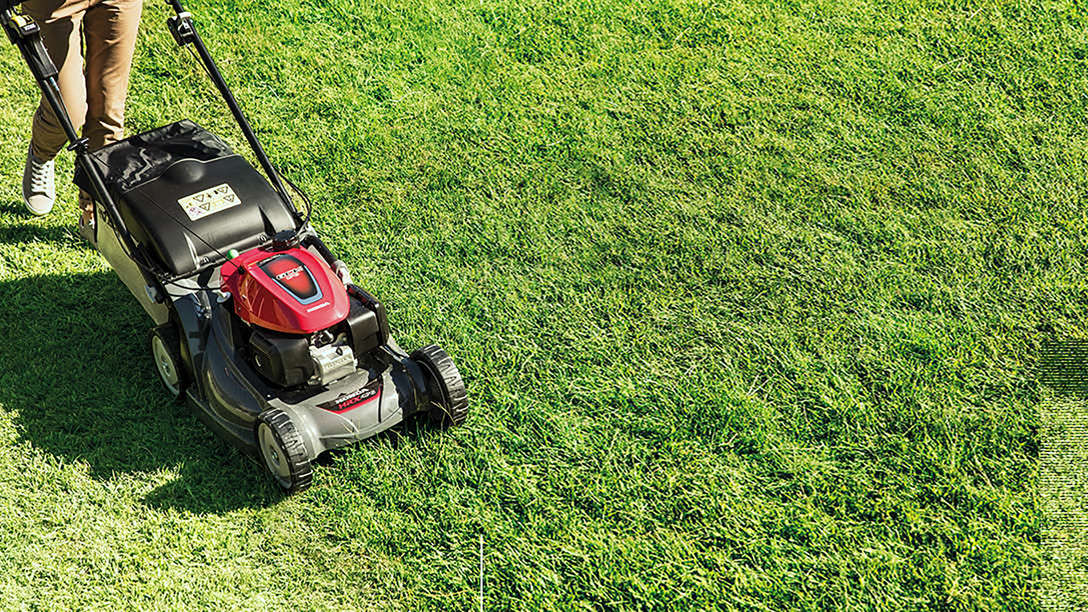 Tondeuse à gazon Honda HRX de trois-quarts face dans un jardin.