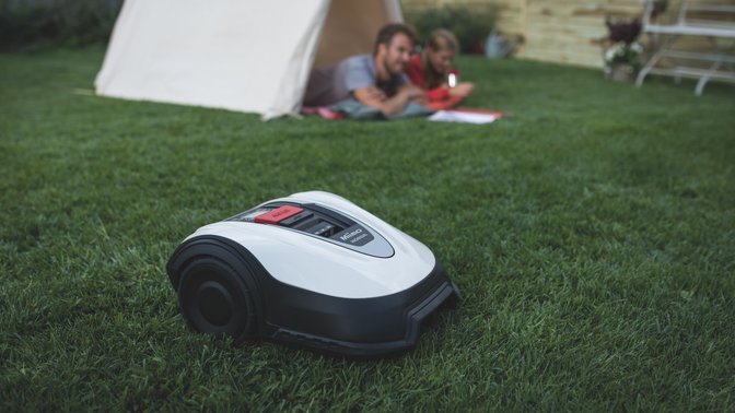 Vue de trois quarts arrière de la Honda Miimo dans un jardin avec des mannequins en arrière-plan.
