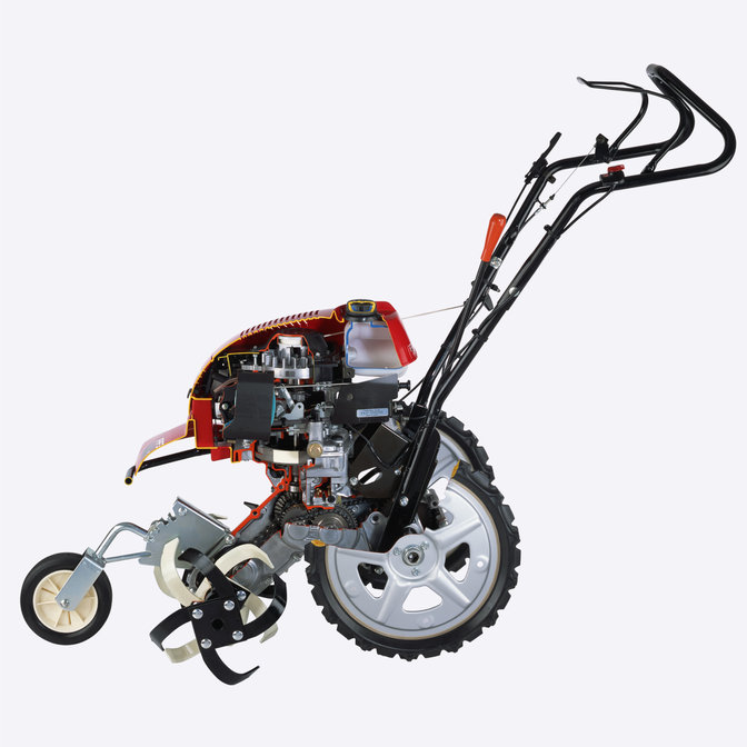Vue latérale de la motobineuse équipée d'outils rotatifs mettant en évidence l'intérieur du moteur.
