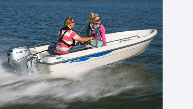 Boat with Honda engine, being used by models, coastal location.