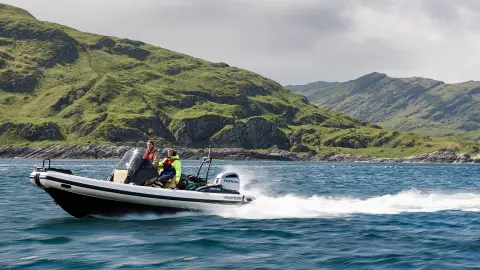 Deux hommes sur un bateau équipé de moteurs Honda sur un lac.