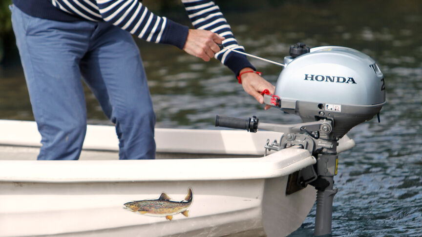 Gros plan du moteur Honda BF2.3 avec accélérateur.