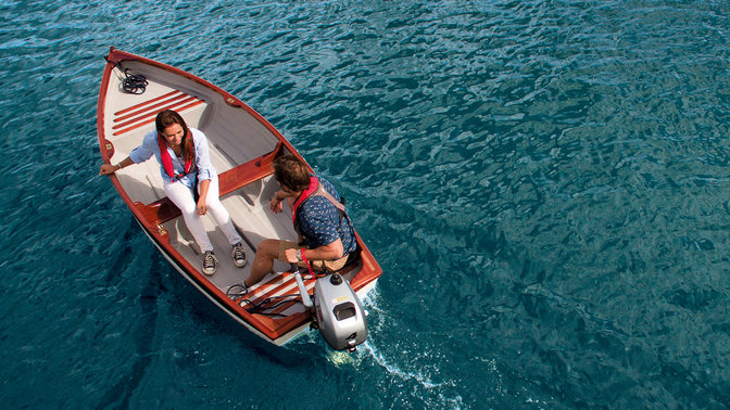 View from above, of a smiling couple in a boat.