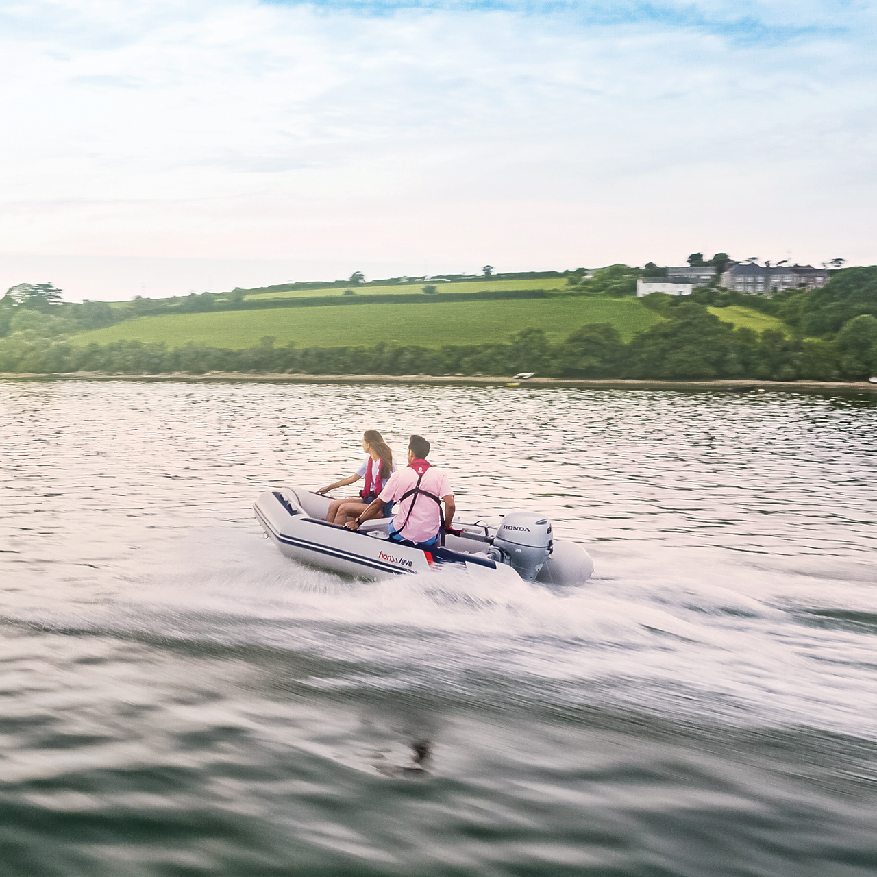 Couple sur un bateau Honwave au bord d’un lac utilisant un moteur Honda BF. 