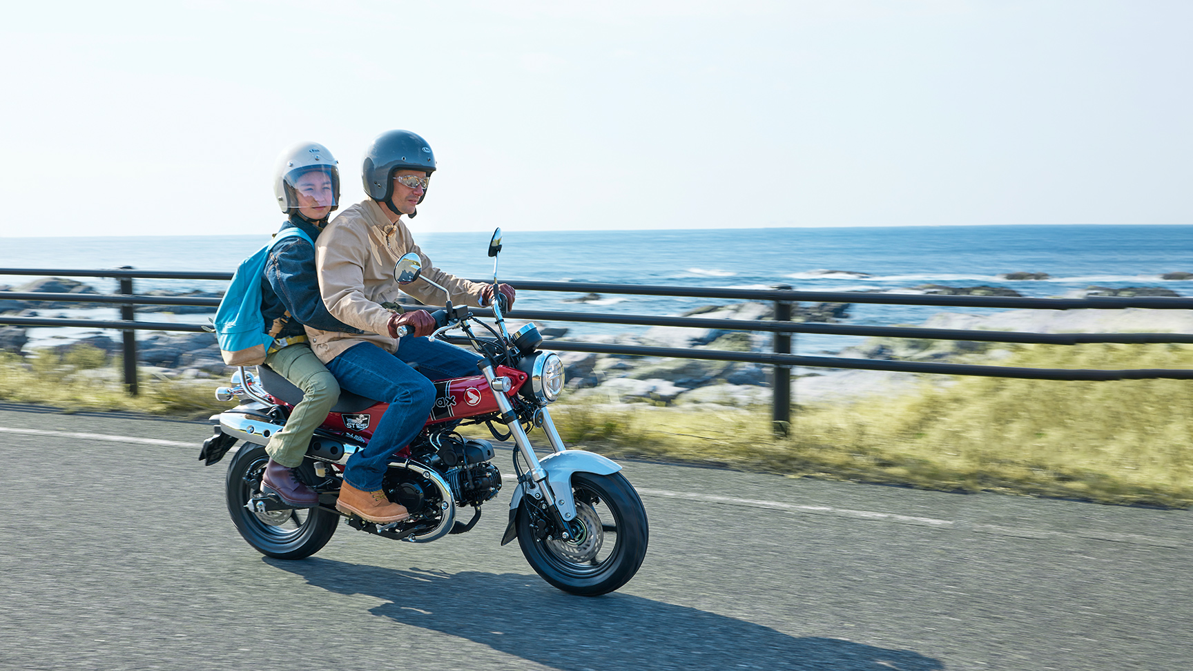 Honda Dax 125 sur une route côtière avec pilote et passager