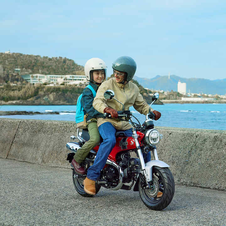 Honda Dax 125 avec la côte en toile de fond