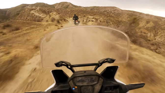 Vue &agrave; la premi&egrave;re personne sur une moto Africa Twin roulant en plein d&eacute;sert