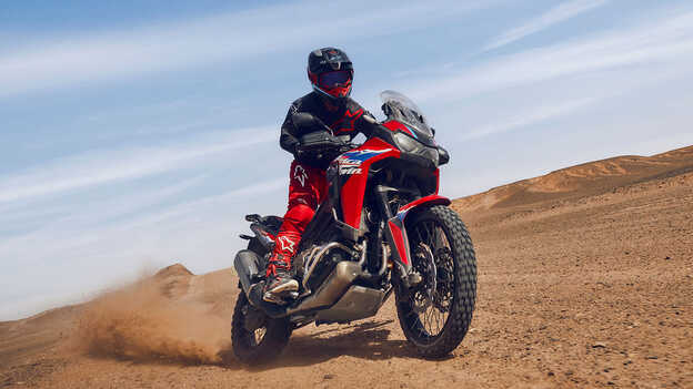 Mannequin sur une moto CRF1100L Africa Twin dans un environnement désertique.