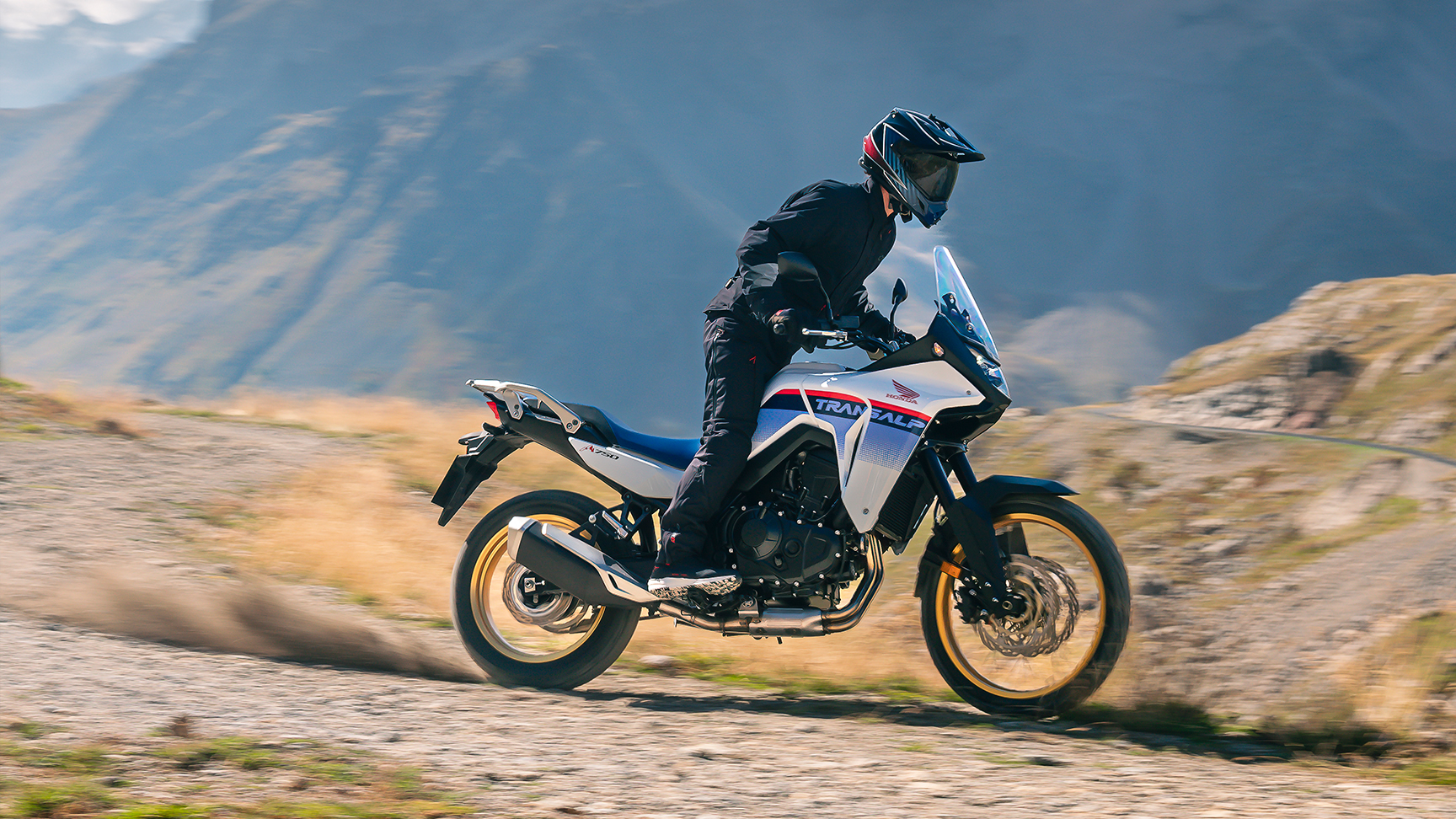 Prise de vue dynamique de la XL750 côté conducteur avec motard