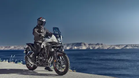 Honda NX500 à l’arrêt avec motard près d’une côte