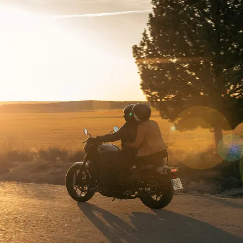 CMX1100 Rebel with pillion riding into the sunset