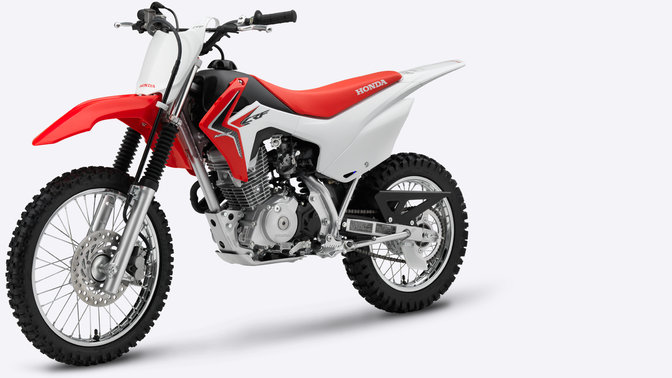 Vue de trois quarts latérale de la CRF125F rouge, côté gauche.
