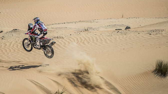 Vue de trois quarts arrière de la Honda CRF450 qui traverse des dunes.
