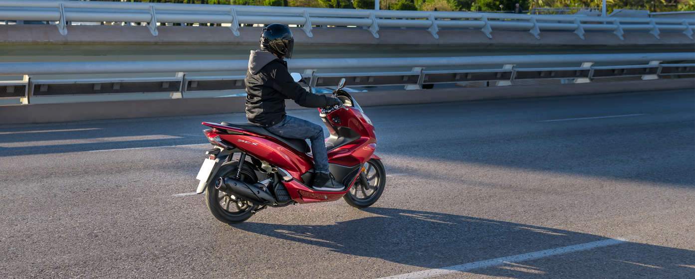 Honda PCX et son pilote dans la rue.