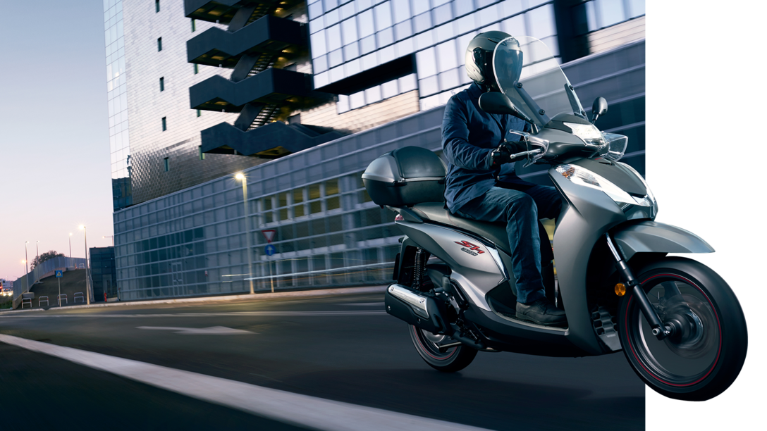 Vue de trois quarts avant du Honda SH300i circulant en ville.