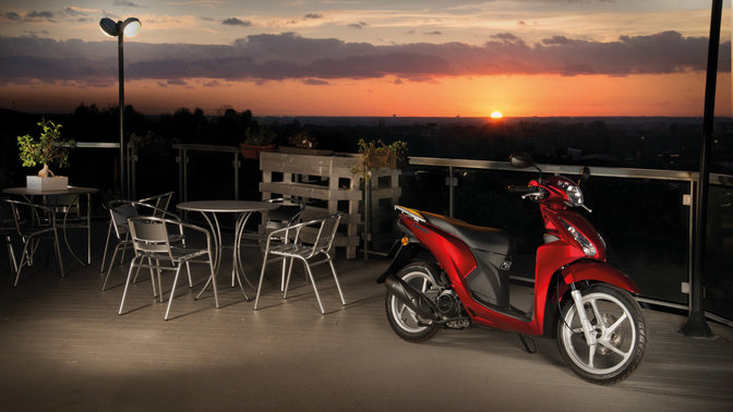 Photo du scooter gar&eacute; &agrave; c&ocirc;t&eacute; d'un caf&eacute;