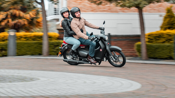 Honda Monkey sur béquille latérale sur une route avec pilote