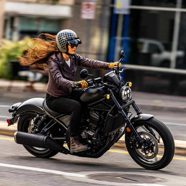 Personnage sur Honda CMX1100 en situation urbaine.