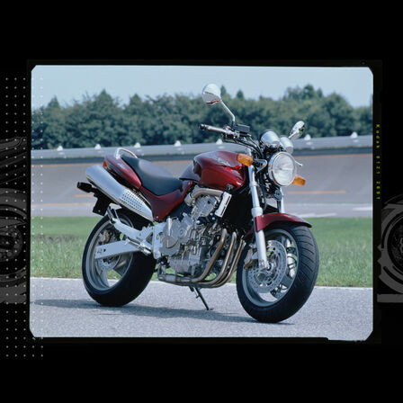 Vue de face de trois quarts de la Honda Hornet, garée sur un circuit de course.