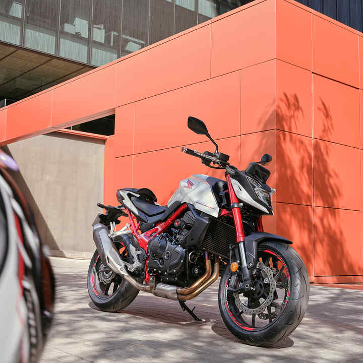moto roadster streefighter Honda CB750 Hornet - permis A2 devant le bâtiment orange.