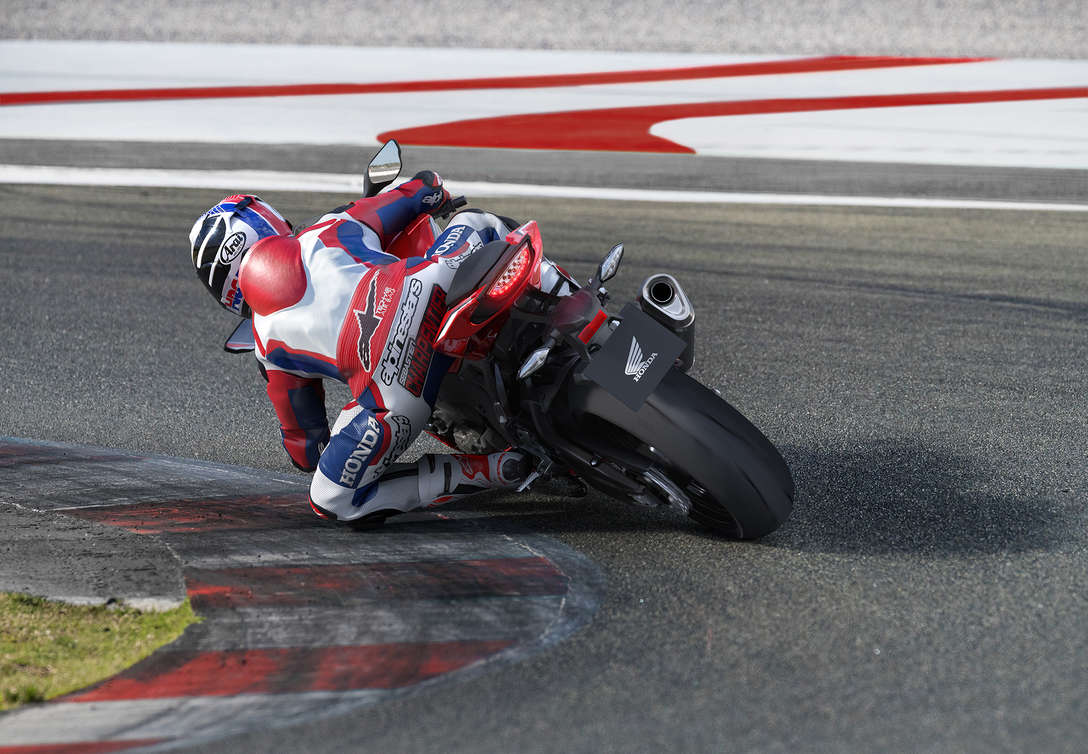 Vue de trois quarts arri&egrave;re gauche de la CBR1000RR Fireblade dans un virage serr&eacute;