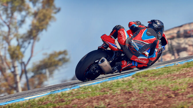 Motard dos à la route sur une Honda CBR100RR-R Fireblade sur piste de course.