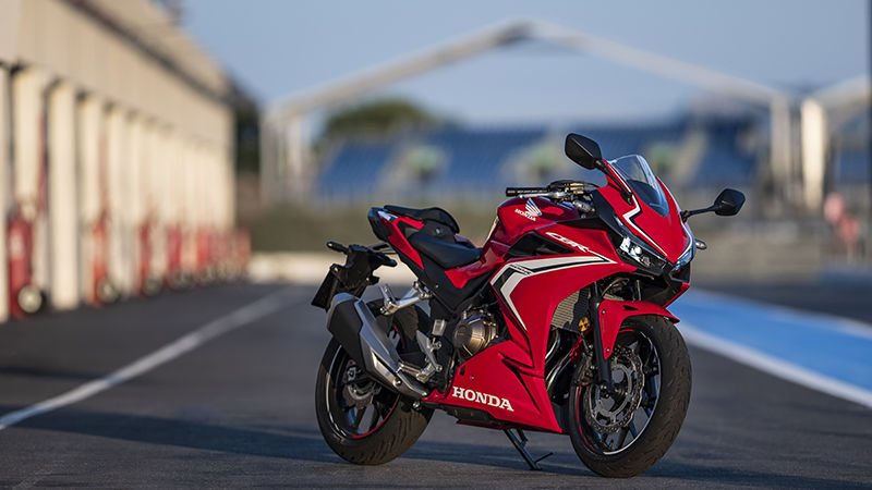 Vue de trois quarts avant droit de la CBR500R, à l'arrêt sur un circuit