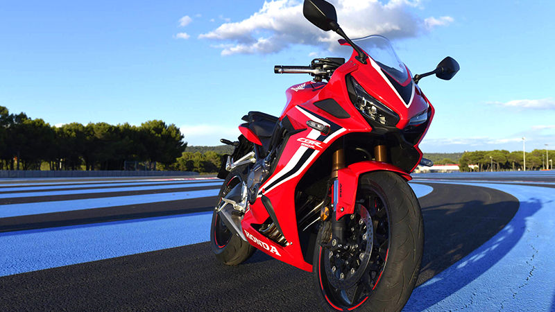 Vue de trois quarts avant droit de la sportive CBR650R, prise à l'arrêt sur un circuit